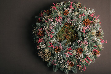 Top down view of a wreath made from spruce branches, cones and other autumnal elements.