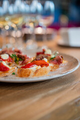 a dish of bruschetta sandwiches with vegetables on a plate in a restaurant