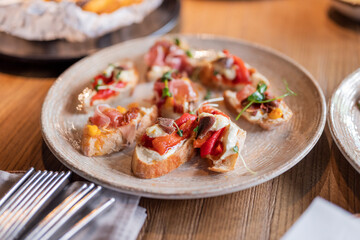 a dish of bruschetta sandwiches with vegetables on a plate in a restaurant