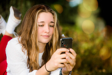 beautiful young woman in nature using her smartphone