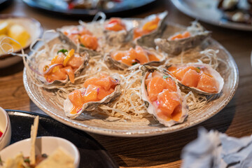 dish tar tar ceviche of salmon in an oyster shell on the table in a restaurant