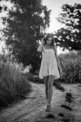 Young beautiful woman in white dress in corn field.