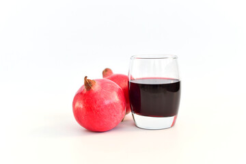 Several pomegranate fruits and glass of juice pomegranate fruits on white background.