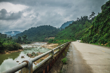 Scenic view of a river next to an asphalt road on a blue sky background
