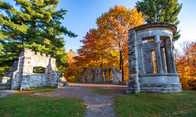 Abbey ruins in autumn with yellow and orange leaves in the background. Mackenzie King Estate, Gatineau Park, Quebec, Canada.
