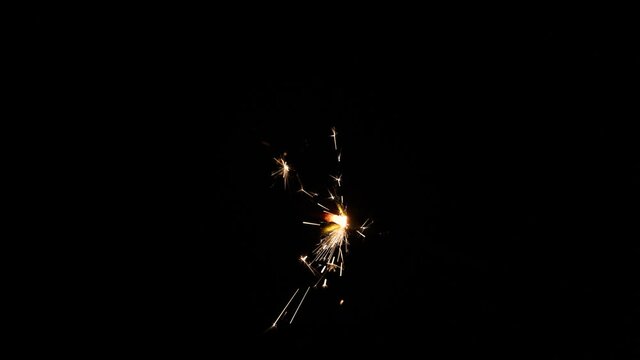Firework sparkler over black in slow motion