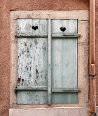 alte verwitterte geschlossene Fensterläden am Haus mit Herz