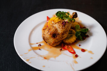 Chicken with corn. Meat with vegetables on dark background. Food cooking process.