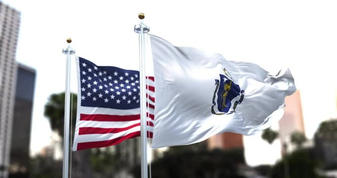 the flag of the US state of Massachusetts waving in the wind with the American flag blurred in the background