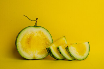 yellow watermelon small cut on a yellow background. High quality photo