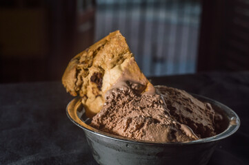 chocolate panettone with chocolate ice cream, dark background and copy space