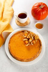 Homemade fresh orange pumpkin pie with physalis.