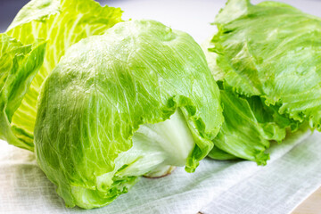 Fresh green iceberg lettuce salad leaves on light background on the table in the kitchen. - 467420885