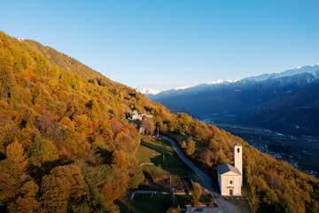 Fototapeta na wymiar autumn aerial view of the small church of Santa Maria, near Carnale in Valtellina, Italy
