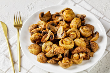 grilled juicy mushrooms on a plate, top view