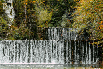 Cascades on stream surrounded by beautiful woodland in autumn