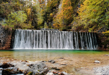 Cascades on stream surrounded by beautiful woodland in autumn