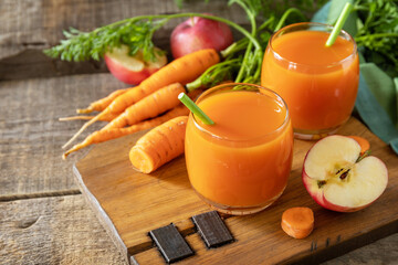 Fresh natural juice, healthy food concept. Glass jar of fresh apple and carrot juice on a wooden rustic table. Copy space.