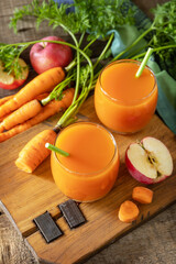 Fresh natural juice, healthy food concept. Glass jar of fresh apple and carrot juice on a wooden rustic table.