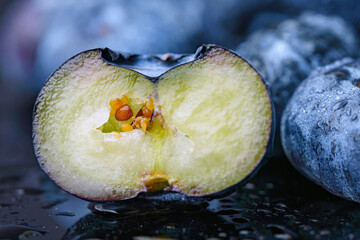 Macro. Cut blueberry berry with orange seeds inside.