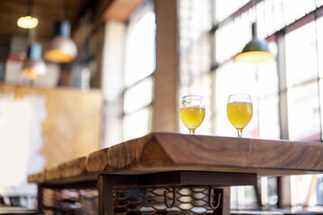 Bottom view of wooden table with alcohol cocktails at cafe. Concept of holiday, party and event. Modern interior. Sunny day. No people