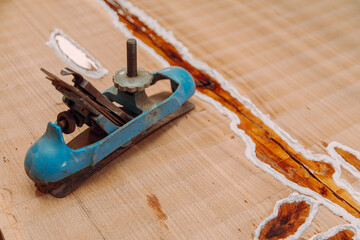 Old metallic jointer plane laying on wood table