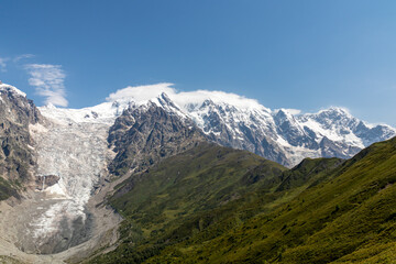 A panoramic view on the snow-capped peaks of Tetnuldi, Gistola, Lakutsia and the Adishi Glacier in the Greater Caucasus Mountain Range in Georgia, Svaneti Region. Sharp peaks, wanderlust, solitude.