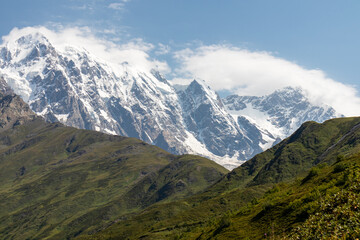 A panoramic view on the snow-capped peak of Jangi-Tau(Dzhangi-Tau) in the Greater Caucasus Mountain Range in Georgia, Svaneti Region. Snowy and glaciated terrain. Mountaineering, freedom, wanderlust.