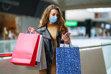 Stylish woman in protective mask after shopping. Black friday. Consumerism, purchases, sale, lifestyle, tourism concept.