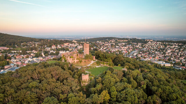 Aerial view over castle K&ouml;nigstein am Taunus to skyline of Frankfurt Main at horizon at sundown