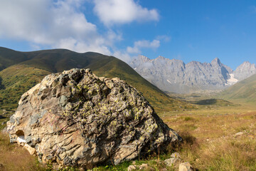 A panoramic view on the sharp mountain peaks of the Chaukhi massif in the Greater Caucasus Mountain Range in Georgia, Kazbegi Region. The valley is full of the Roshka stones. Georgian Dolimites.