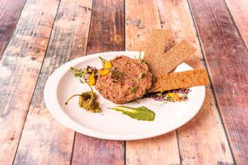 The steak is a dish made with raw minced beef. It is usually served with finely chopped onion, capers and various ingredients, sometimes an egg yolk is added.