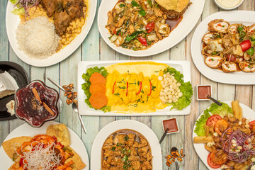 Set of typical Peruvian recipes, huancaina potatoes, fish tiradito, roast duck with rice, wantan, purple mazamorra, rolled chicken, lomo saltado, seafood jelly