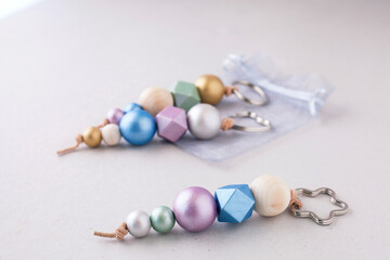 Selective approach of painted wooden bead key chains for car or bag on light background. Wooden...