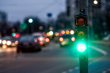 traffic light on the street junction with beautiful bokeh, city with cars in the background