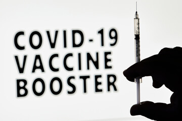 Covid-19 Vaccine booster dose. Hand of the doctor holds a syringe with new Covid vaccine booster...