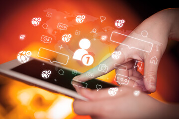 Close-up of a hand using tablet, social media concept