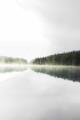 misty morning on the lake with reflections in the water