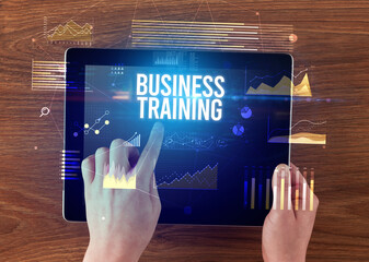 Close-up of hands holding tablet with business inscription