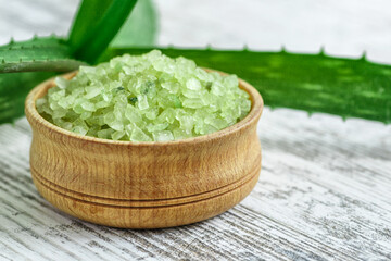 Pieces of aloe vera with pulp on a wooden background.Aloe vera essential oil or serum with sliced Aloe vera.skin care and hair care concept.Aloe leaf slices with drops