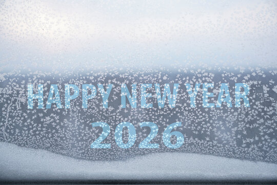 Winter iced pattern on frozen window glass, bad ventilation concept, cold temperature outside and inside. energy or power crisis. 2026  happy new year inscription.