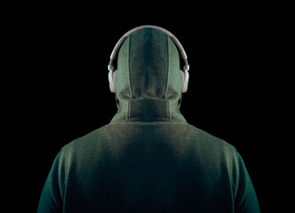 unrecognizable man in the hood in white headphones.  back , rear view. isolated on black...