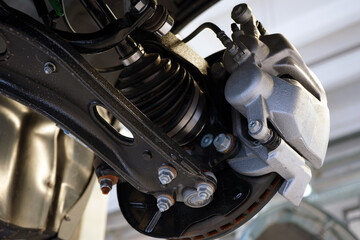 Close-up shows the suspension arm of a modern car in place of the connection with a ball joint and...