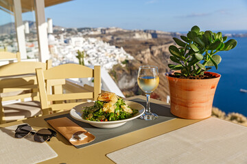 Dinner at a restaurant overlooking the sea and the island of Santorini, Greece