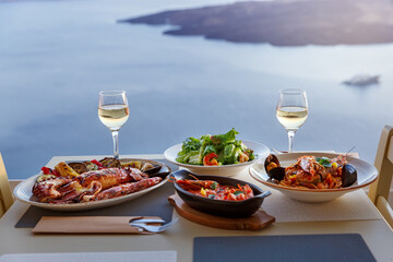 Dinner for two in a restaurant overlooking the sea and the island of Santorini, Greece