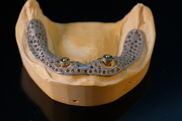 Dental technician works by brush with jaw model