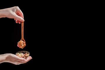 Wooden spoon with peanut butter and peanuts on a black background