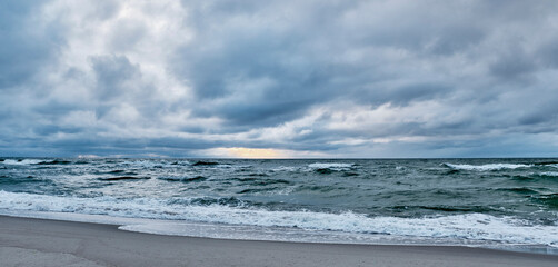 Seascape as background. Dramatic sunset on the Baltic Sea. Sandy beach
