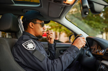 Male police officer talking on a walkie-talkie