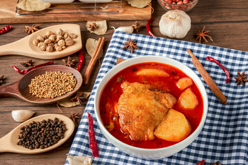 Chicken Massaman Curry on white bowl. Muslim curry or mussaman curry.  Muslim style chicken and potato or chicken mussaman curry.